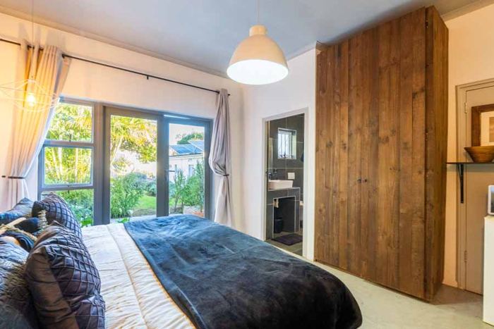 Bedroom with patio doors opening to the garden in Lemon Cottage